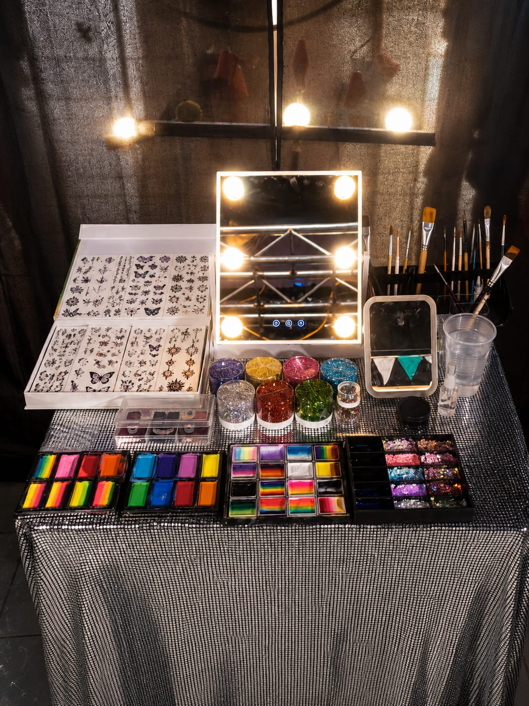 Estación de glitter con frascos de brillo de colores y gemas sobre la mesa